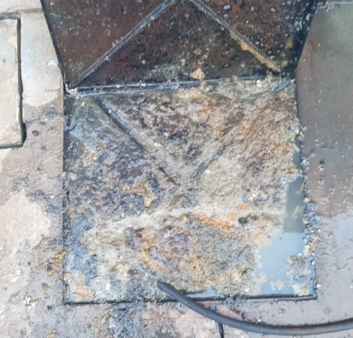 Serviço de desentupimento de caixa de gordura em andamento
